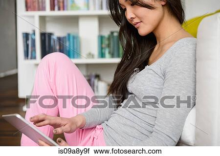 Stock Image - Woman surfing the internet on digital tablet. Fotosearch