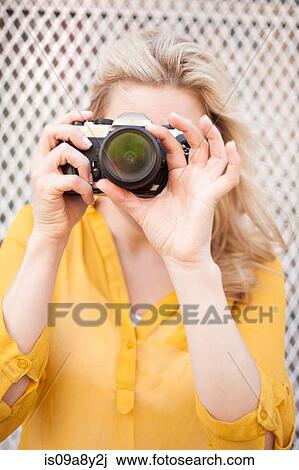 Stock Image - Woman taking photo with camera. Fotosearch