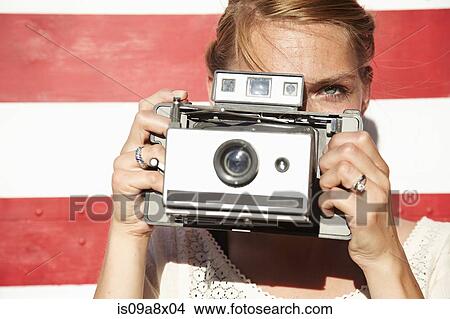 Picture - Woman taking photograph using vintage camera. Fotosearch