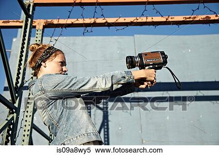 Woman using old video camera to take self portrait View Large Photo Image Stock Photography - Woman using old video camera to take self portrait. Fotosearch