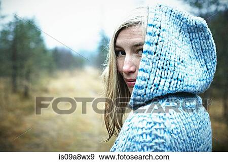Stock Photo - Woman wearing hooded top in forest. Fotosearch