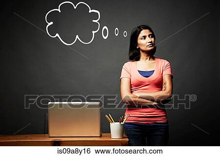 Stock Photograph - Woman with arms crossed day dreaming. Fotosearch
