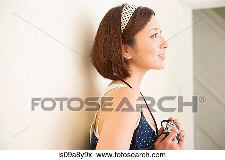 Stock Photo - Woman with camera looking into distance. Fotosearch