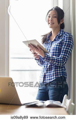 Woman with digital tablet looking at camera View Large Photo Image Stock Photo - Woman with digital tablet looking at camera. Fotosearch
