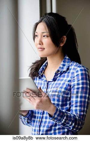 Woman with digital tablet looking into distance View Large Photo Image Stock Image - Woman with digital tablet looking into distance. Fotosearch
