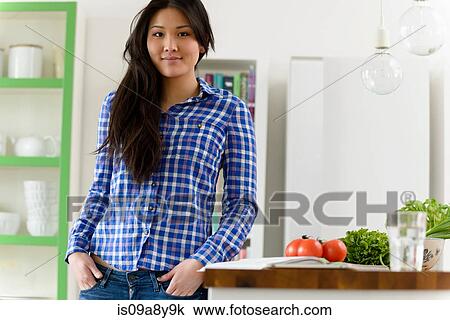 Stock Image - Woman with hands in pockets looking at camera. Fotosearch