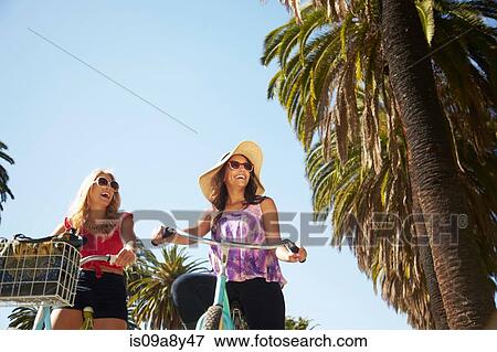 Stock Photo - Women chatting on bicycle. Fotosearch