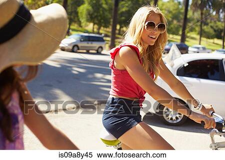 Stock Photography - Women chatting on bicycle. Fotosearch
