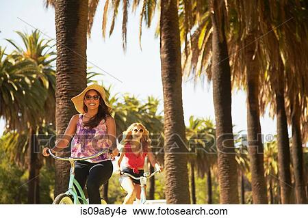 Stock Image - Women on bicycle laughing. Fotosearch
