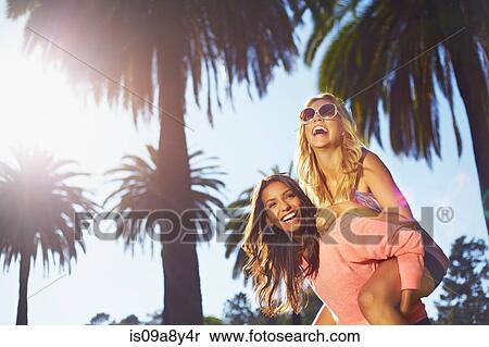 Stock Photography - Women playing piggy back. Fotosearch