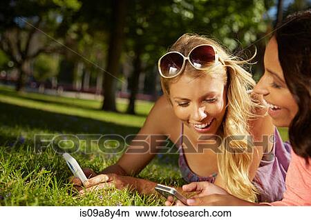 Women sharing text messages on phone View Large Photo Image Picture - Women sharing text messages on phone. Fotosearch