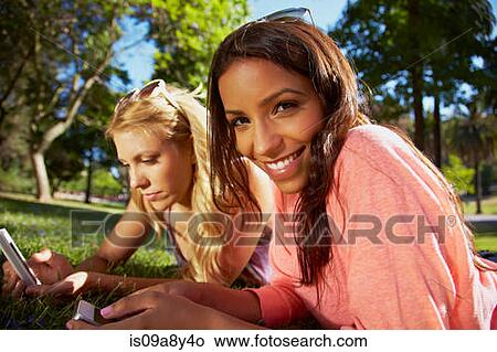 Women sharing text messages on phone View Large Photo Image Picture - Women sharing text messages on phone. Fotosearch