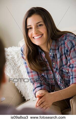 Stock Image - Young brunette woman wearing checked shirt. Fotosearch