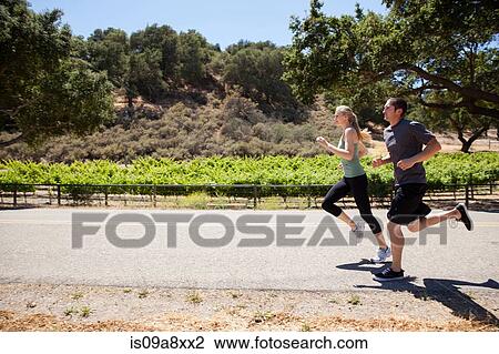 Young couple jogging on road View Large Photo Image Stock Image - Young couple jogging on road. Fotosearch