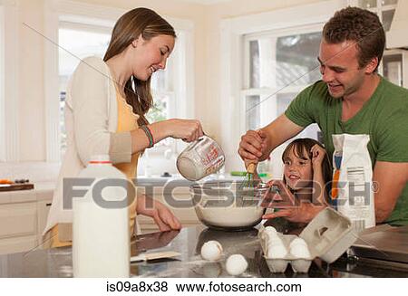 Stock Photo - Young girl baking with older brother and sister. Fotosearch