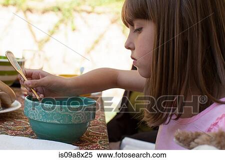 Stock Photography - Young girl eating breakfast. Fotosearch