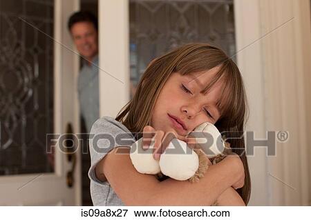 Stock Photo - Young girl hugging teddy bear. Fotosearch