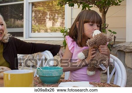 Stock Photograph - Young girl kissing teddy bear. Fotosearch