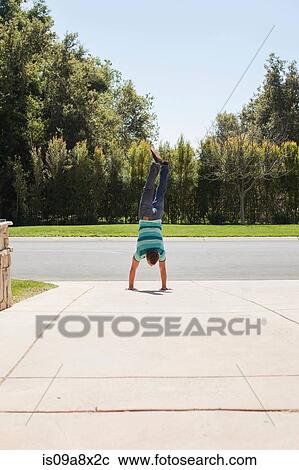 Young man doing handstand on driveway View Large Photo Image Stock Image - Young man doing handstand on driveway. Fotosearch