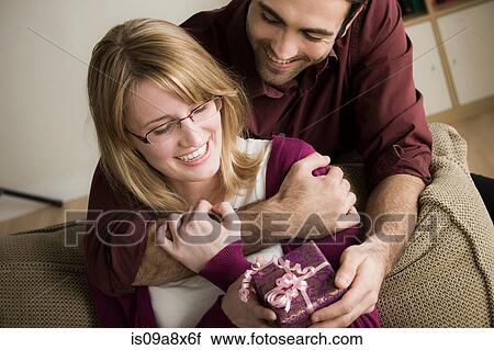 Young man giving woman gift View Large Photo Image Stock Image - Young man giving woman gift. Fotosearch