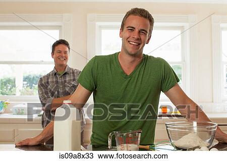 Young man in kitchen smiling, portrait View Large Photo Image Stock Image - Young man in kitchen smiling, portrait. Fotosearch