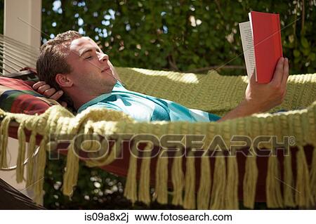 Young man reading book in hammock View Large Photo Image Stock Image - Young man reading book in hammock. Fotosearch