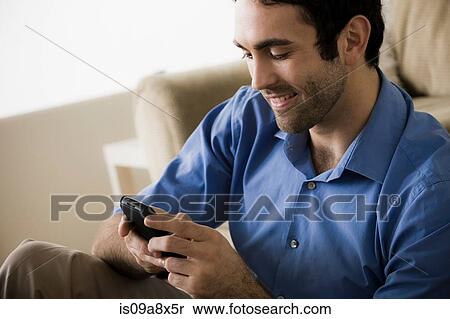 Stock Photography - Young man using cell phone. Fotosearch
