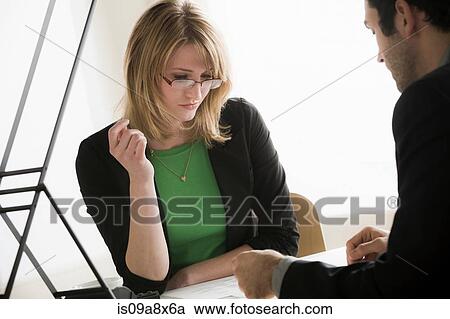 Young office workers looking through paperwork View Large Photo Image Stock Image - Young office workers looking through paperwork. Fotosearch