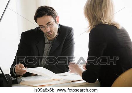 Young office workers looking through paperwork View Large Photo Image Stock Image - Young office workers looking through paperwork. Fotosearch