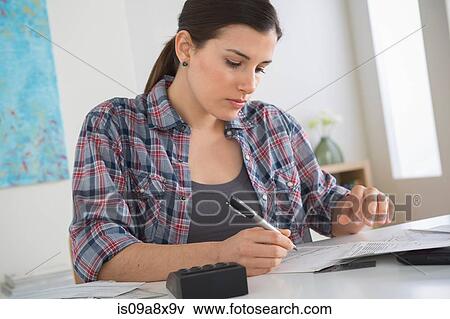 Stock Photo - Young woman doing home finances. Fotosearch