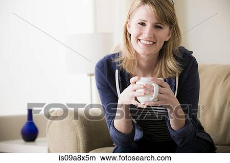 Picture - Young woman holding coffee. Fotosearch