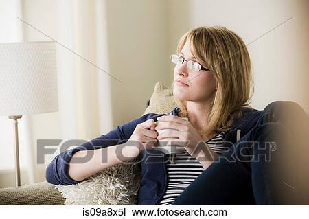 Stock Image - Young woman holding coffee. Fotosearch