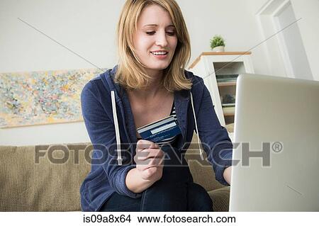 Picture - Young woman shopping online with credit card. Fotosearch