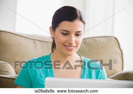 Young woman using laptop, smiling View Large Photo Image Stock Photograph - Young woman using laptop, smiling. Fotosearch