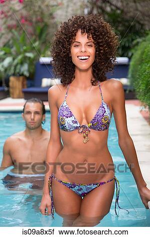 Stock Image - Young woman wearing bikini in swimming pool. Fotosearch