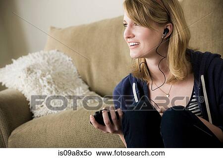 Picture - Young woman wearing earphones. Fotosearch