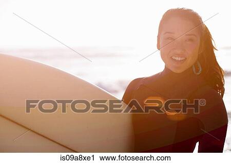 Young woman wearing wetsuit with surfboard View Large Photo Image Stock Image - Young woman wearing wetsuit with surfboard. Fotosearch