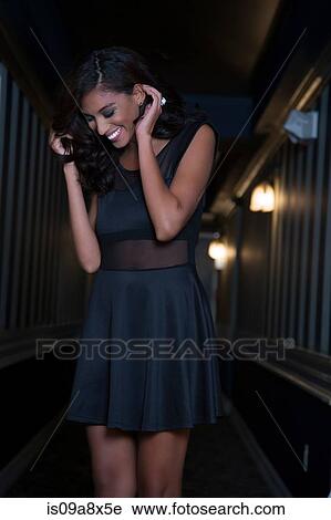 Young woman with hand in hair, looking down laughing View Large Photo Image Stock Image - Young woman with hand in hair, looking down laughing. Fotosearch