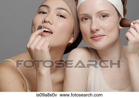 Young women putting on make up View Large Photo Image Stock Photo - Young women putting on make up. Fotosearch