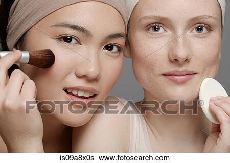 Stock Photograph - Young women putting on make up. Fotosearch
