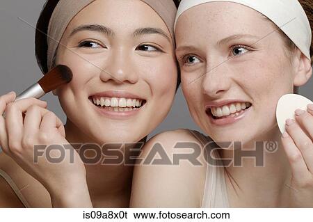 Stock Photograph - Young women putting on make up. Fotosearch