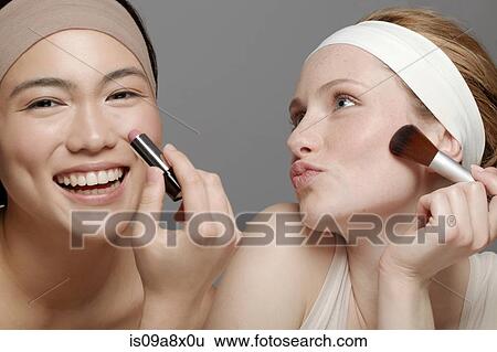 Young women putting on make up View Large Photo Image Stock Photograph - Young women putting on make up. Fotosearch