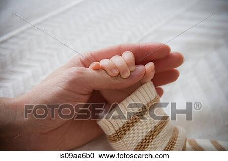 Baby boy holding mother's hand, close up View Large Photo Image Stock Image - Baby boy holding mother's hand, close up. Fotosearch