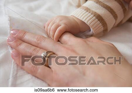 Baby boy holding mother's hand, close up View Large Photo Image Stock Photograph - Baby boy holding mother's hand, close up. Fotosearch