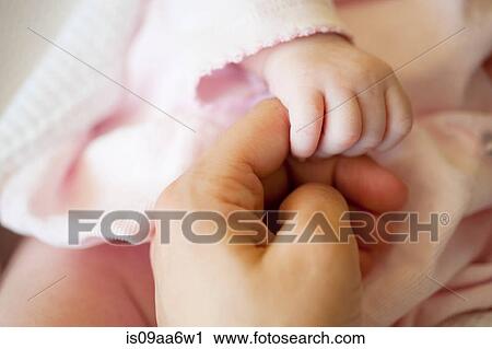 Baby girl holding mid adult woman's finger, close up View Large Photo Image Stock Image - Baby girl holding mid adult woman's finger, close up. Fotosearch