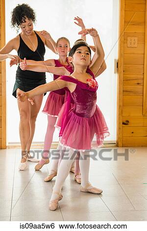 Stock Photograph - Ballerinas practising with ballet teacher. Fotosearch