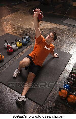 Bodybuilder lifting kettlebell in gym View Large Photo Image Stock Image - Bodybuilder lifting kettlebell in gym. Fotosearch