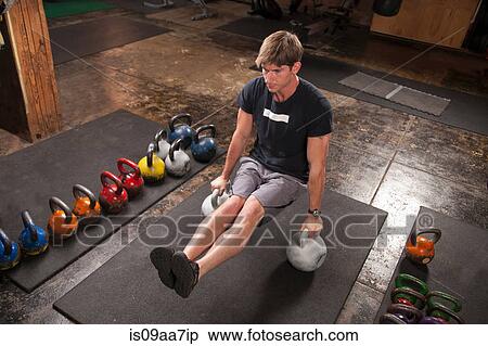 Bodybuilder on floor in gym using kettlebells View Large Photo Image Stock Photography - Bodybuilder on floor in gym using kettlebells. Fotosearch