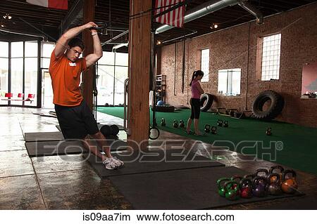 Picture - Bodybuilder using rings in gym. Fotosearch