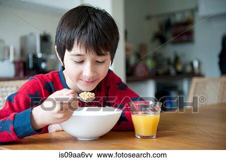 Boy eating breakfast cereal at table View Large Photo Image Stock Photo - Boy eating breakfast cereal at table. Fotosearch